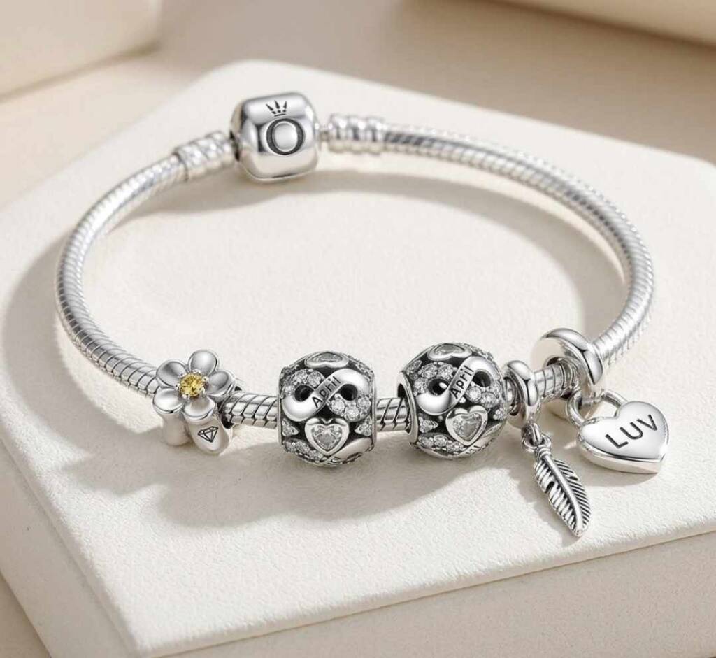 Родените през април: Пролетен огън и инат, който мести планини! Сребърна гривна с талисмани сърца и нежно перо, идеален аксесоар с детайлен дизайн за рожден ден на родените през април.